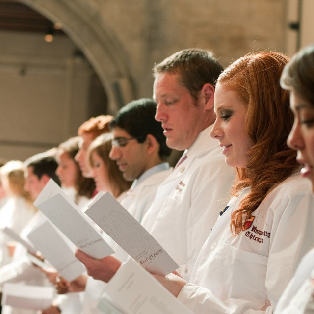 Photo of Pritzker students in white coats taking the hippocratic oath
